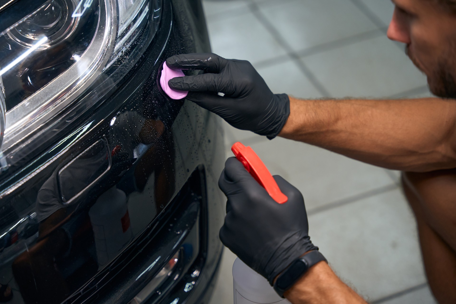 Close up of man is detailing a black car